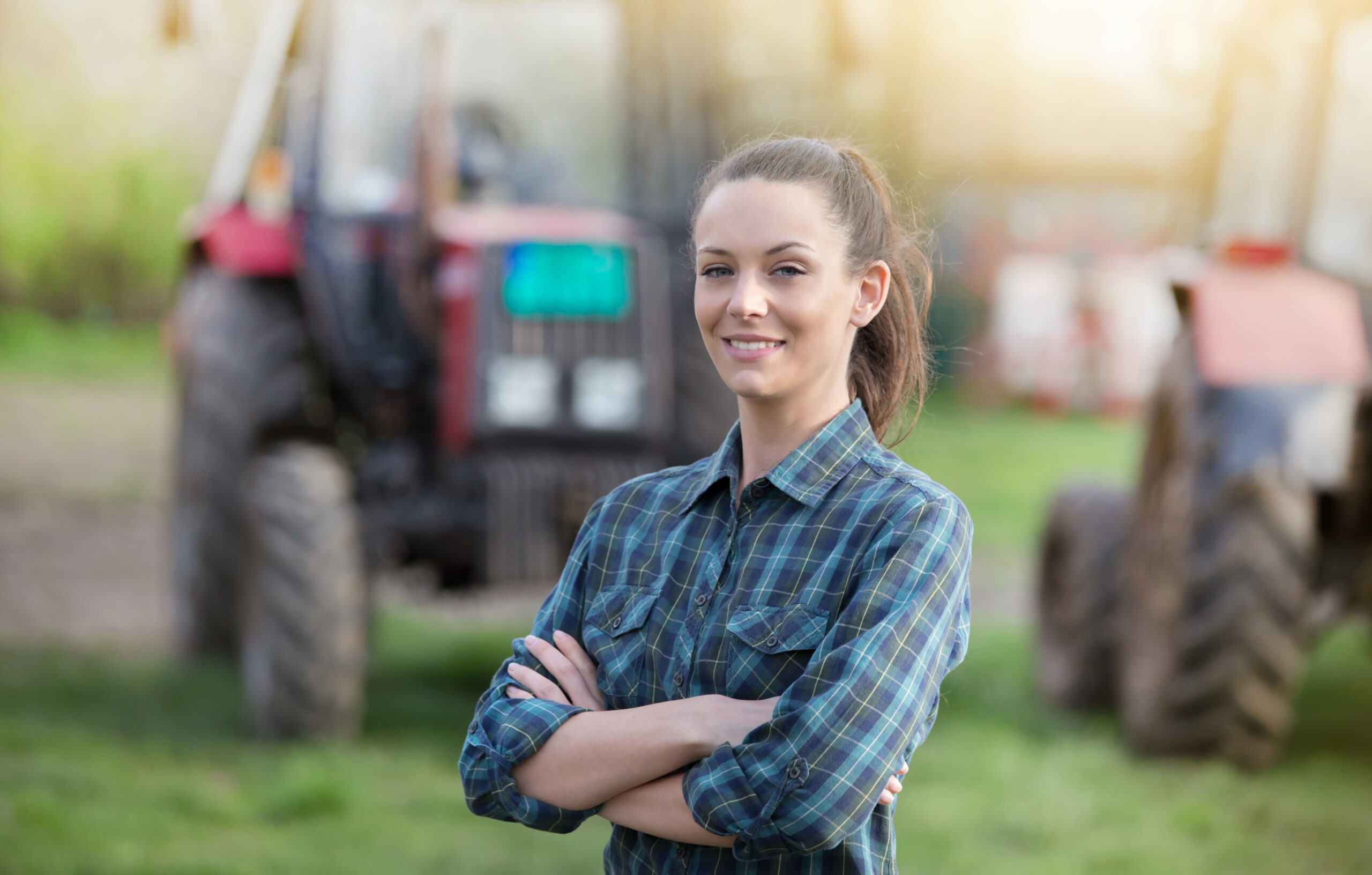 Farmer standing with tractors on working farmland